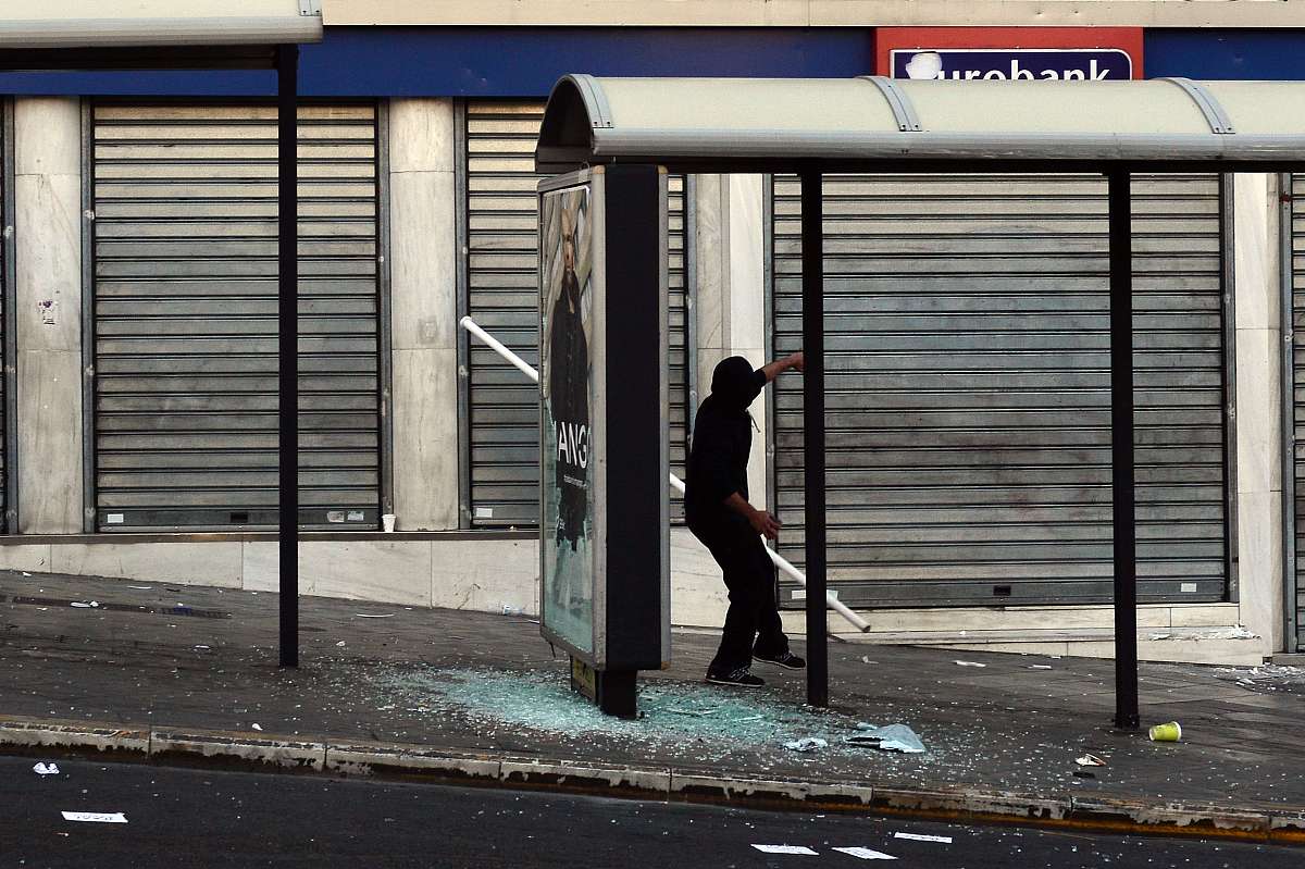 a man tries to smash windows of a bank office during a massive d