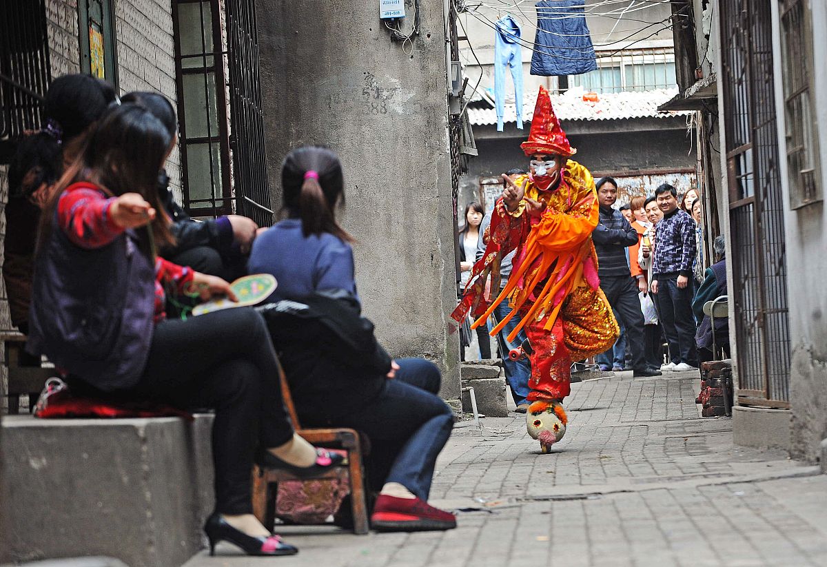 2012年4月13日,武汉,小丑卡卡穿街走巷,引起街坊邻里的围观.+++_+++轮