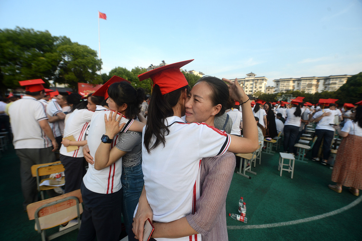 ***_***2018年6月15日,在江苏扬州第一中学成人礼上,家长为孩子佩戴"
