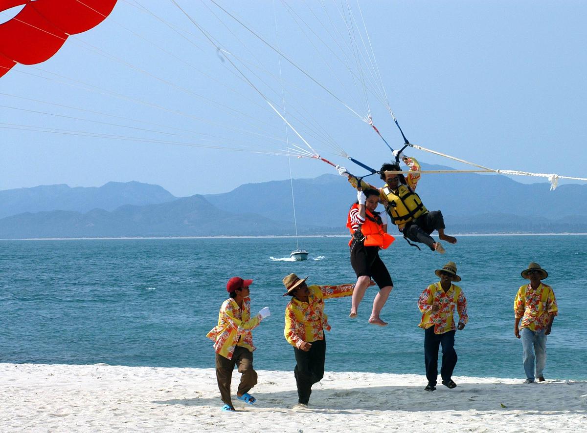 2004年5月4日,游客在海南体验海上拖伞的心跳感觉.五一黄金周海南虽然