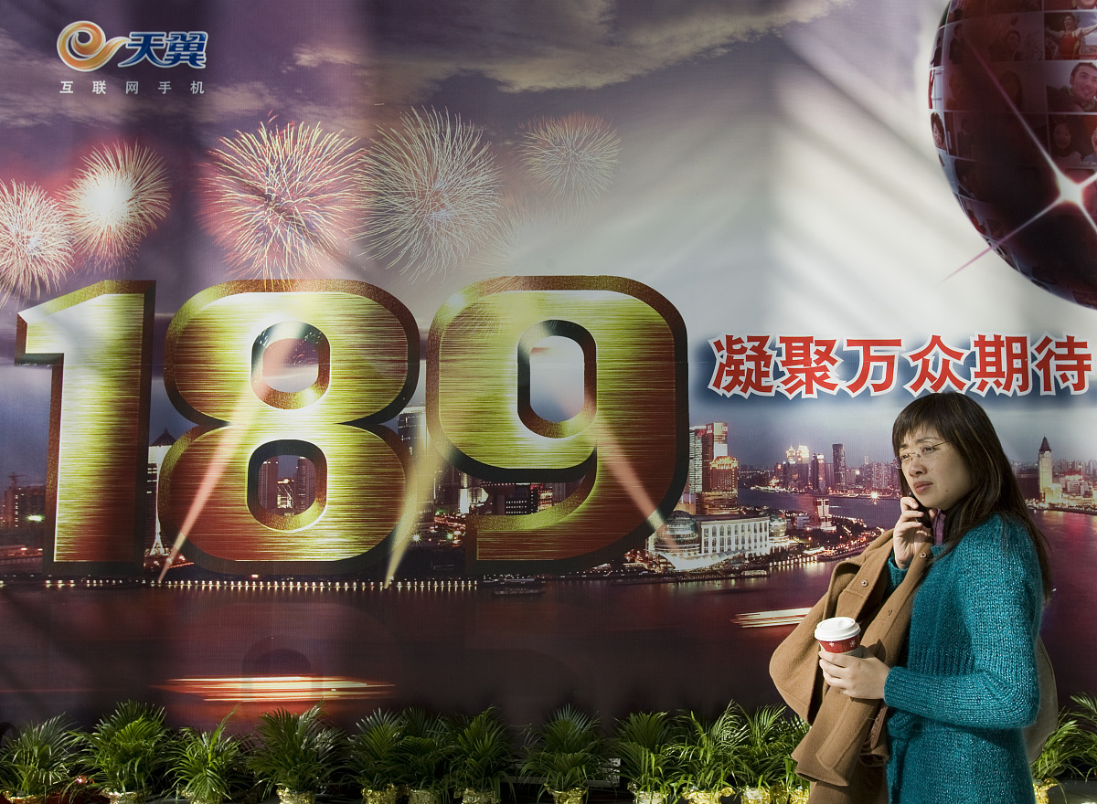 ***_***2008年12月18日,市民打着手机走过中国电信"189"号码宣传广告+
