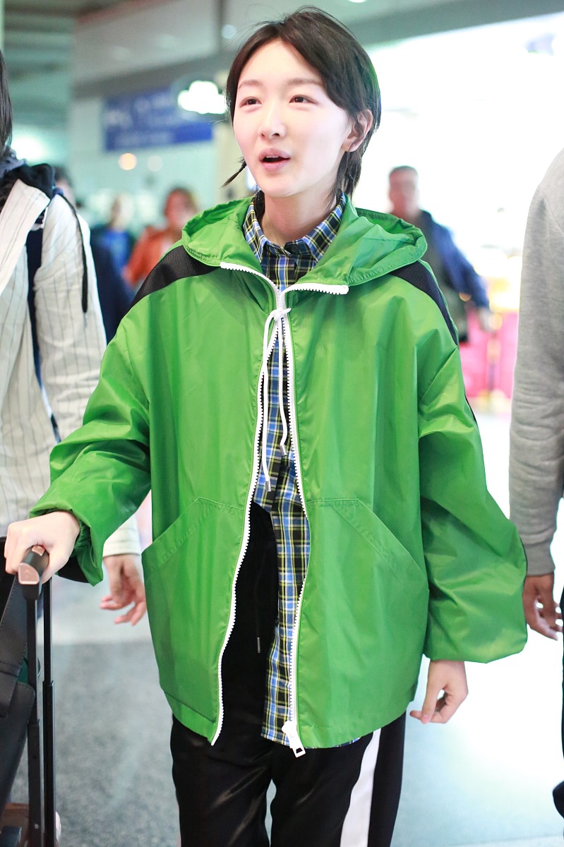 她外面披着既简约又鲜艳的淡绿色羽绒服外套这句话改进一下