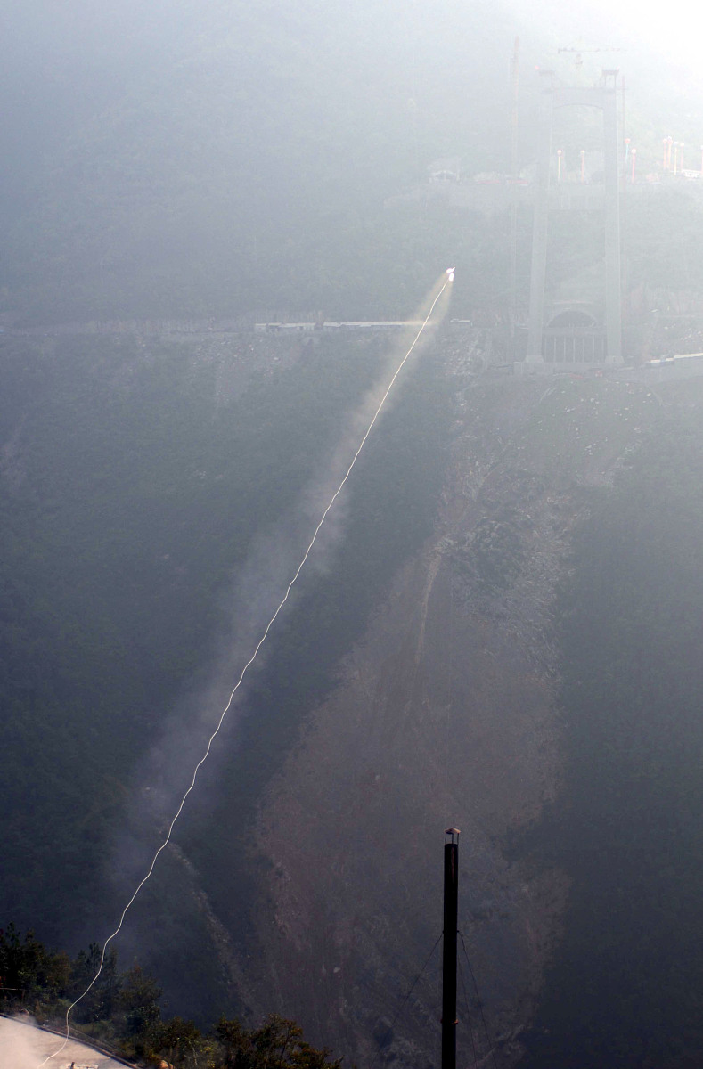 2006年10月9日,一枚小型火箭在湖北省巴东县四渡河西岸腾空而起,牵引