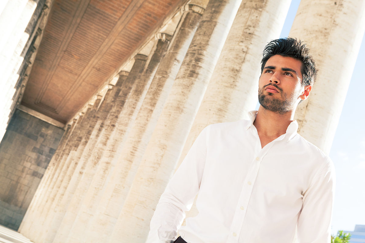 handsome young elegant man outdoors. hairstyle and beard.