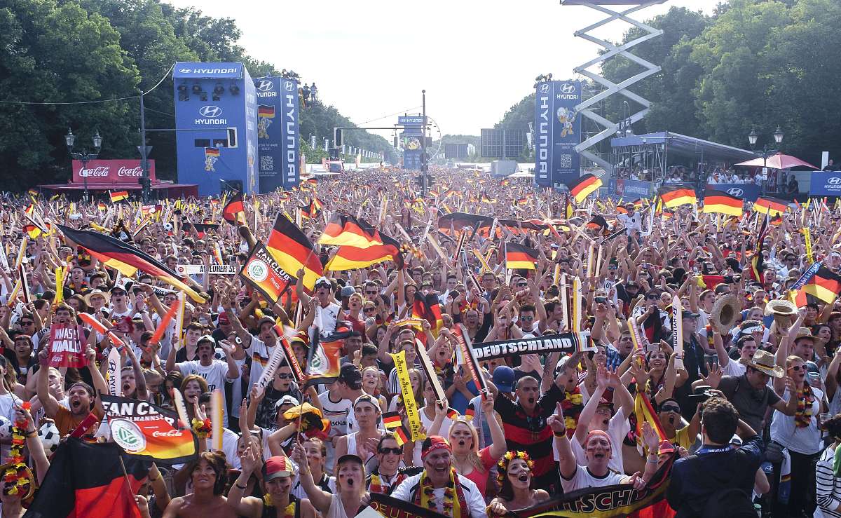 german football fans cheer as they watch on a giant screen the f
