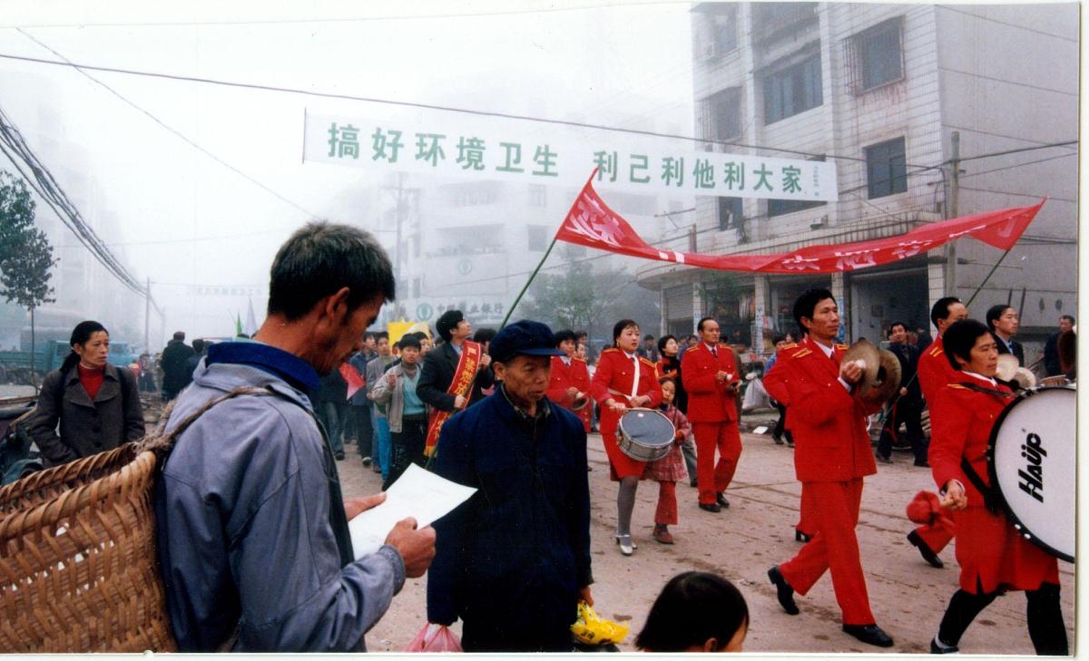 一名群众在街头认真阅读刚发放的"文明公约".+++_+++小康,十六大