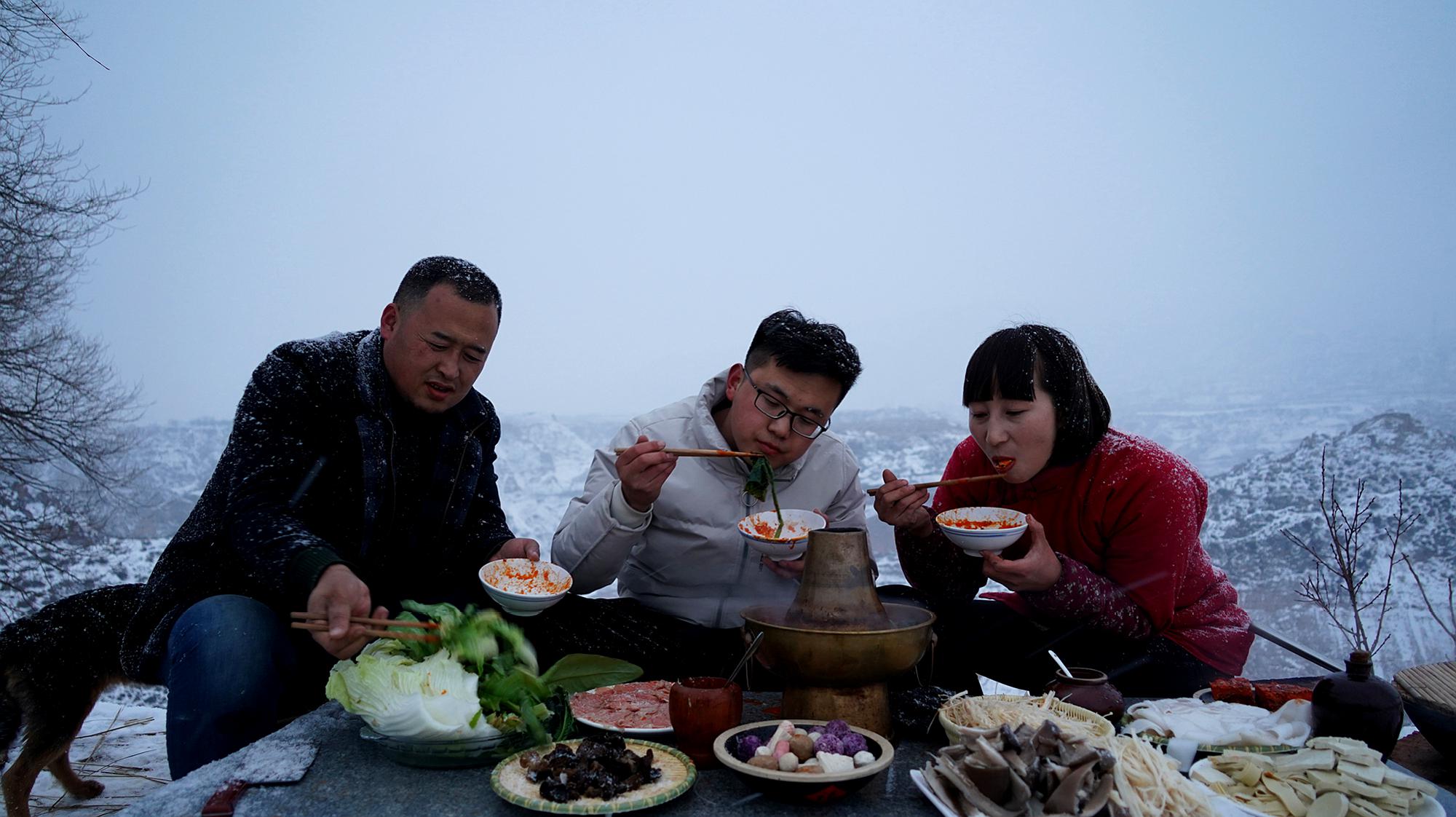 [图]天空飘着大雪，3个人坐在山头吃火锅，体验过的都后悔了