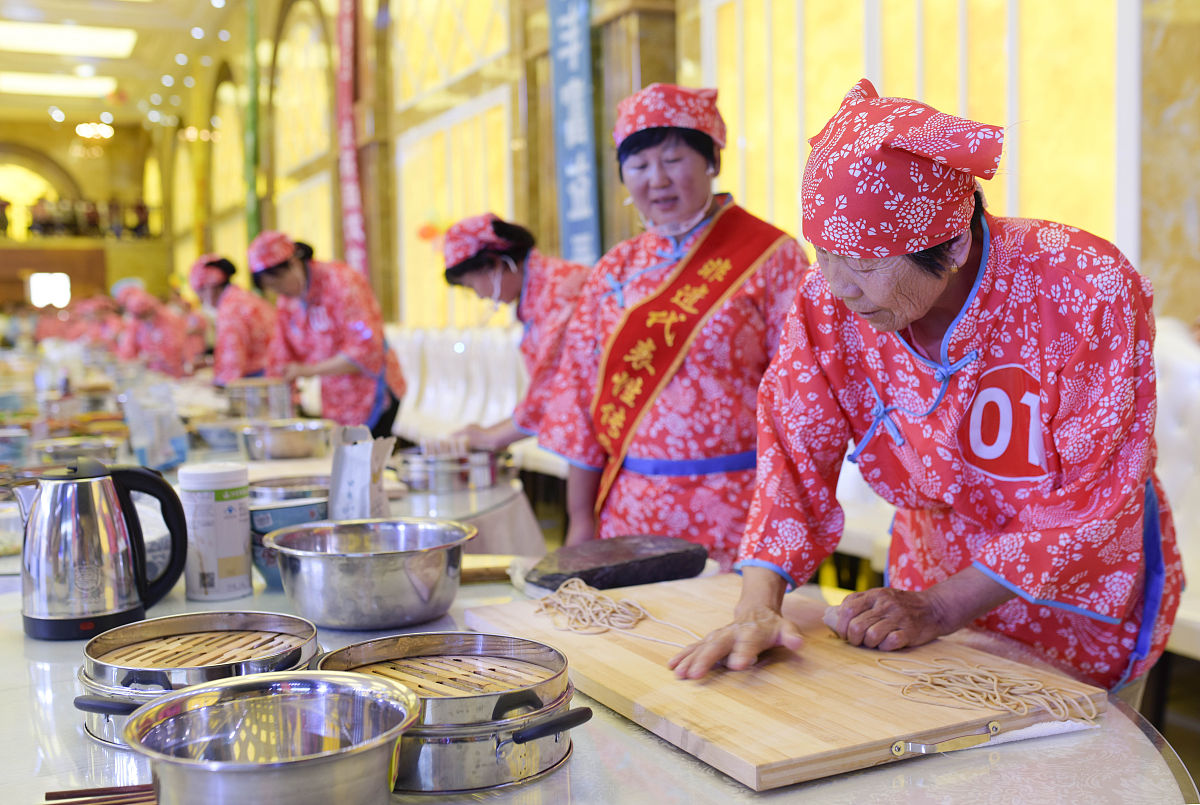 2019年8月9日,呼和浩特,参赛选手在莜面美食技能大赛上制作武川莜面.