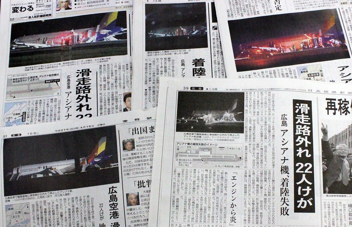 当地时间2015年4月15日,在日本广岛机场,工作人员对事故原因等进行调