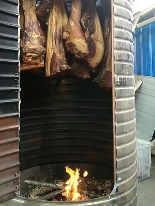师傅在油桶上安装电风扇罩,制作的熏腊肉神器,大家瞧瞧怎么样