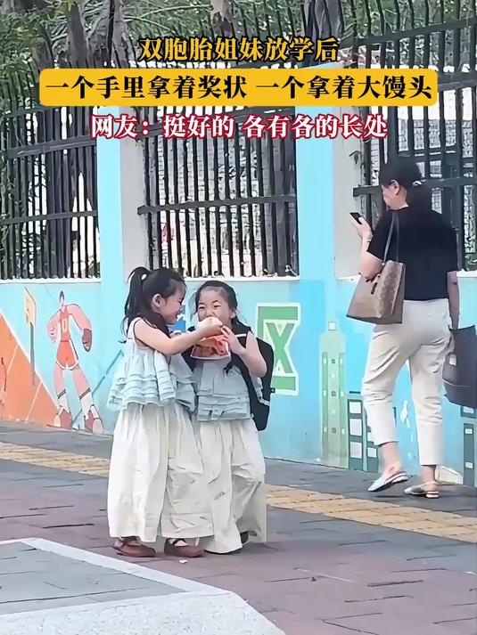 双胞胎姐妹放学后，一个手里拿着奖状，一个拿着大馒头