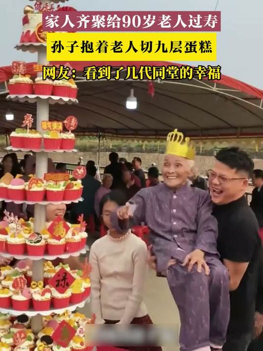 家人齐聚给90岁老人过寿,孙子抱着老人切九层蛋糕