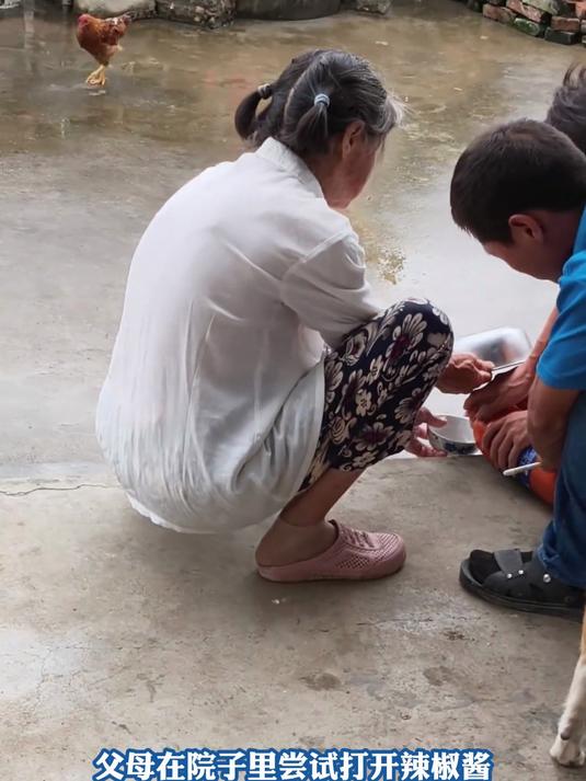 父母在院子里尝试打开辣椒酱，下一秒因为气体胀气瓶子飞了出去