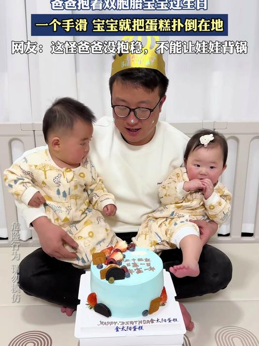 爸爸抱着双胞胎宝宝过生日，一个手滑宝宝就把蛋糕扑倒在地