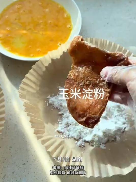 女生将腌过的鸡排从冷冻中拿出,裹上蛋液和面包糠,速成炸鸡排