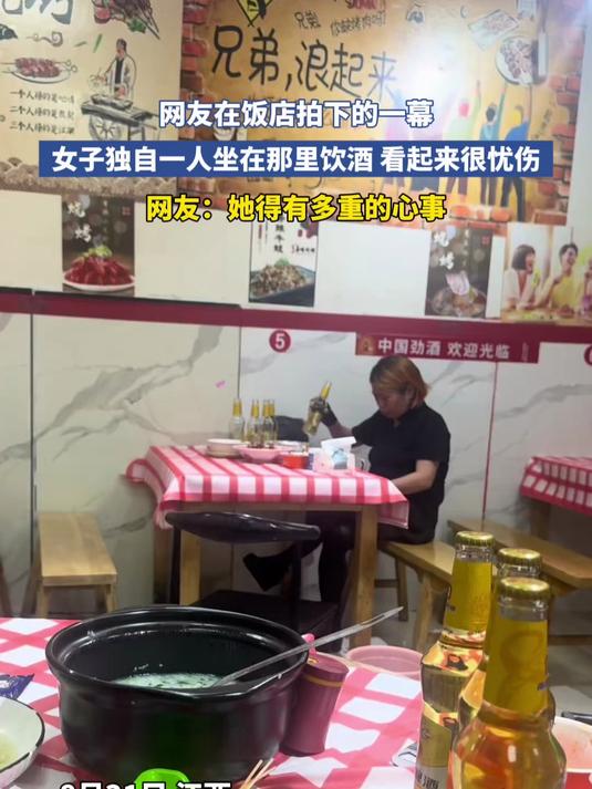 网友在饭店拍下的一幕,女子独自一人坐在那里饮酒,看起来很忧伤