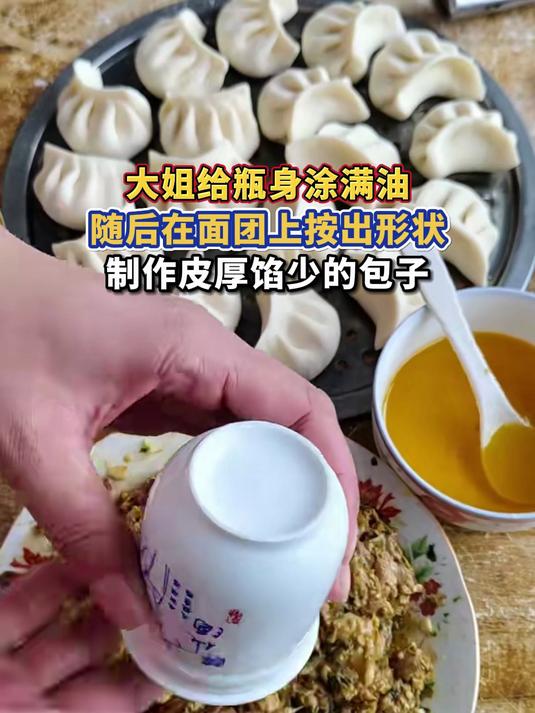 大姐给瓶身涂满油,随后在面团上按出形状,制作皮厚馅少的包子