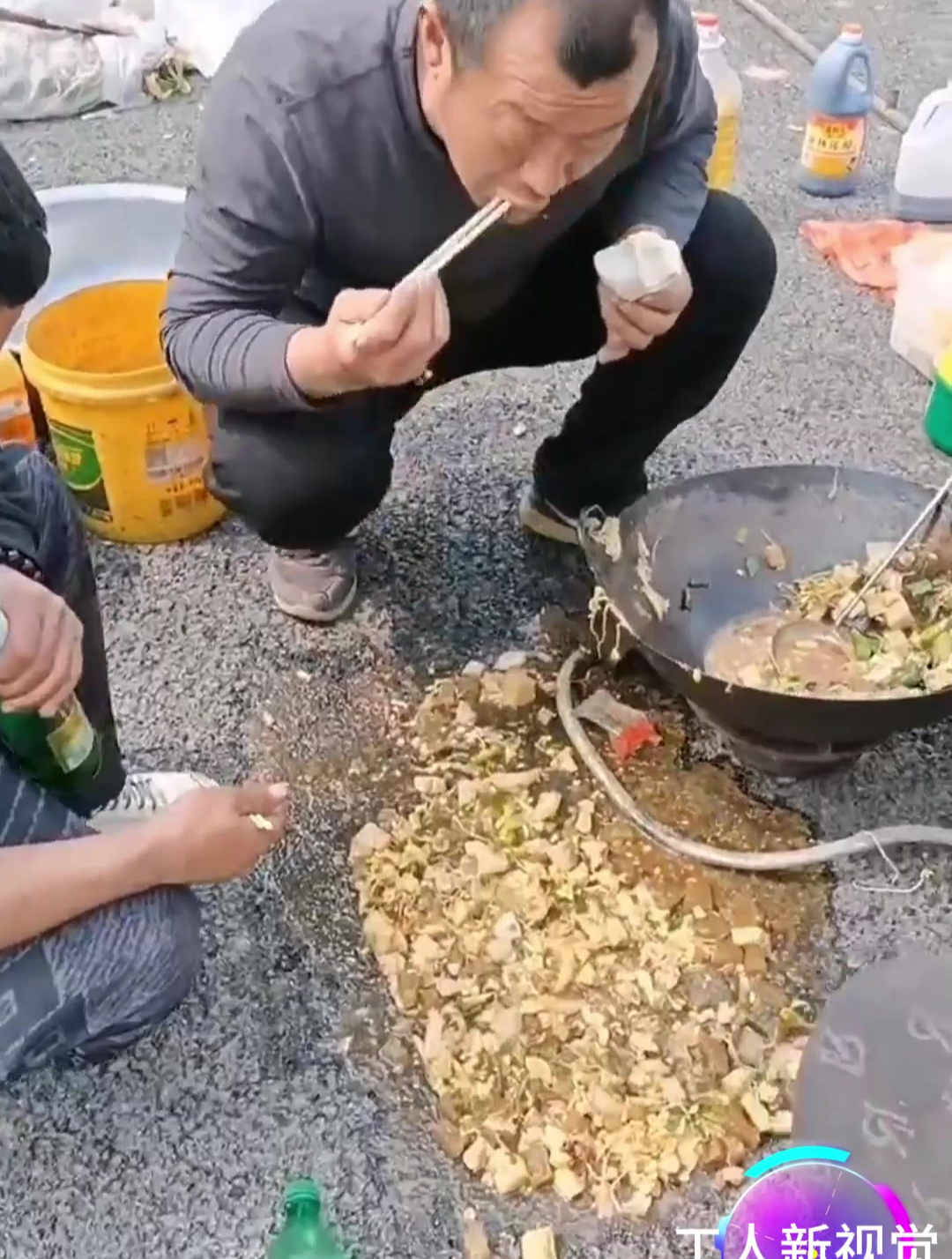 大锅菜被吹翻散落一地,农民工就着馒头吃起地上的菜,不吃饿肚子