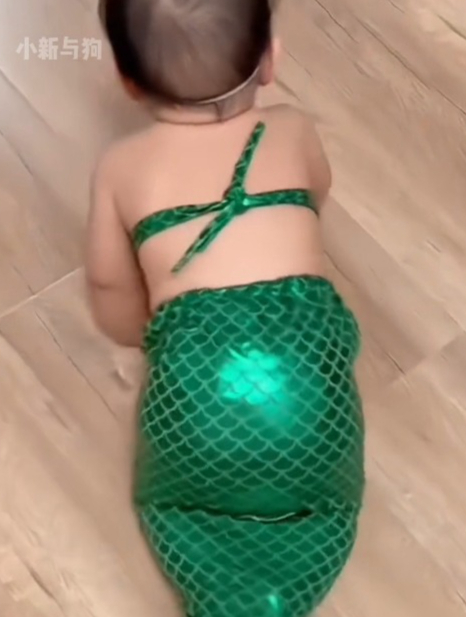 宝宝穿在美人鱼鱼尾,在地上爬行,那副模样让人忍俊不禁