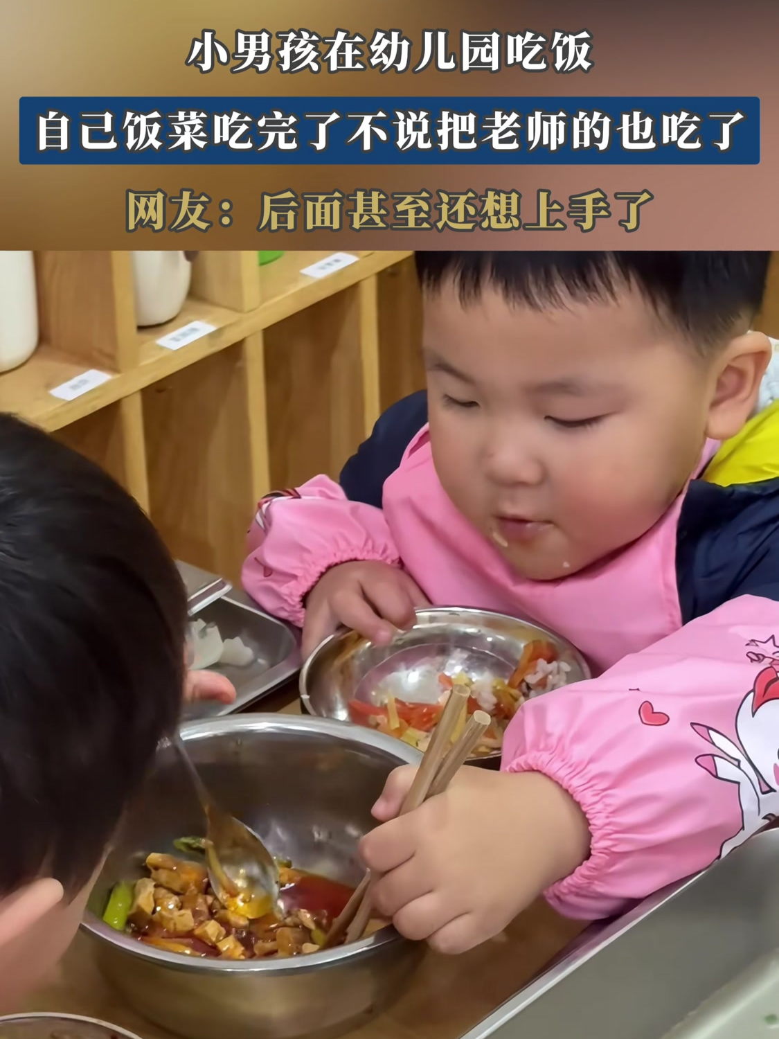 小男孩在幼儿园吃饭,自己饭菜吃完了不说把老师的也吃了