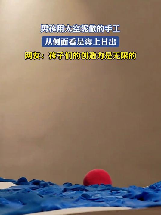 男孩用太空泥做的手工,从侧面看是海上日出