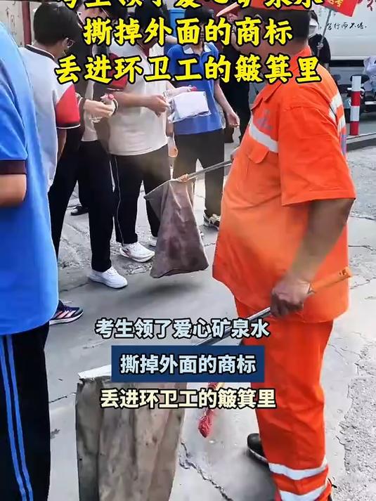 考生领了爱心矿泉水,撕掉外面的商标,丢进环卫工的簸箕里