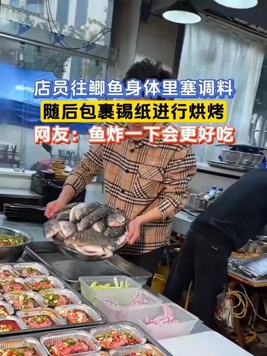 店员往鲫鱼身体里塞调料,随后包裹锡纸进行烘烤