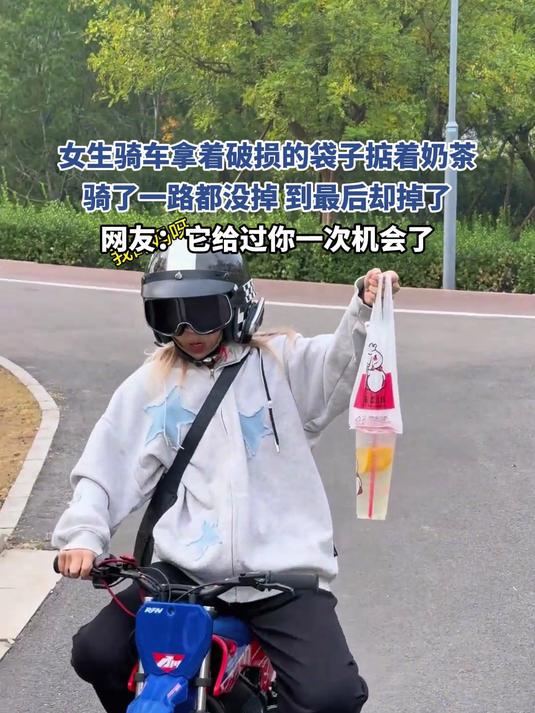 女生骑车拿着破损的袋子掂着奶茶,骑了一路都没掉,到最后却掉了