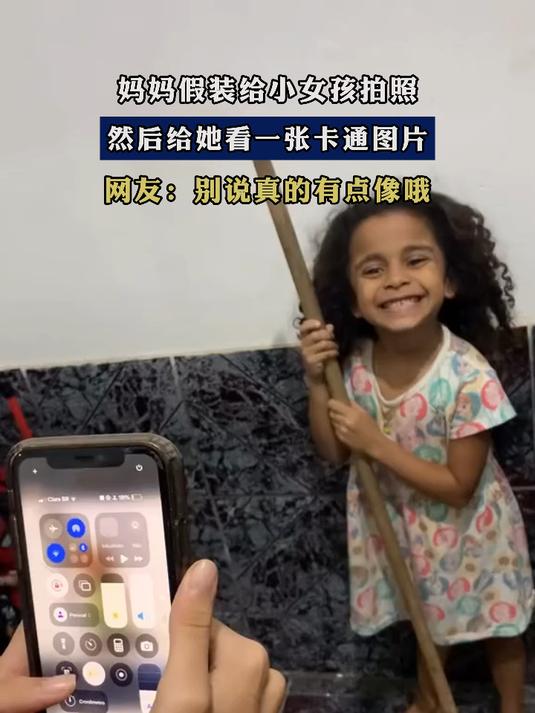 妈妈假装给小女孩拍照,然后给她看一张卡通图片