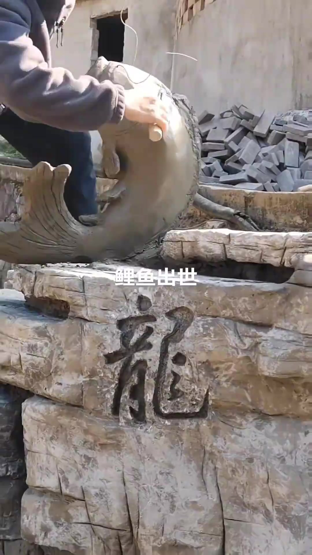 匠心独运:师傅手工打造栩栩如生的假山鲤鱼石
