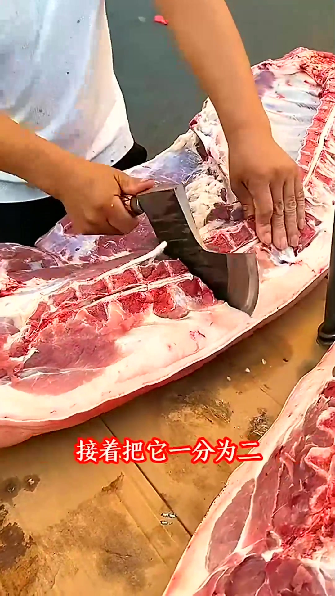 男子切割猪肉，肥瘦相间