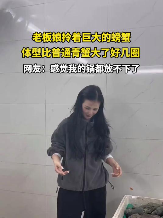 老板娘拎着巨大的螃蟹，体型比普通青蟹大了好几圈