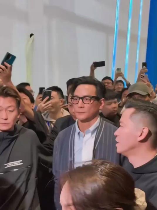 吴彦祖现身上海车展身穿条纹毛衫，搭配咖色工装阔腿裤，硬帅