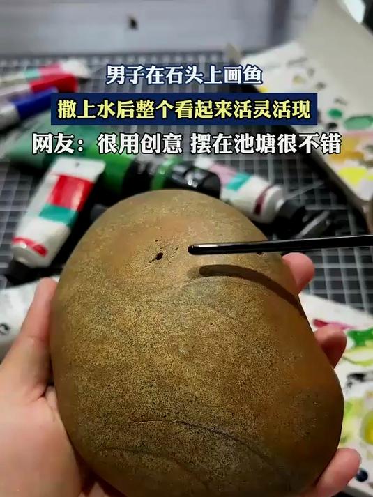 男子在石头上画鱼,撒上水后整个看起来活灵活现