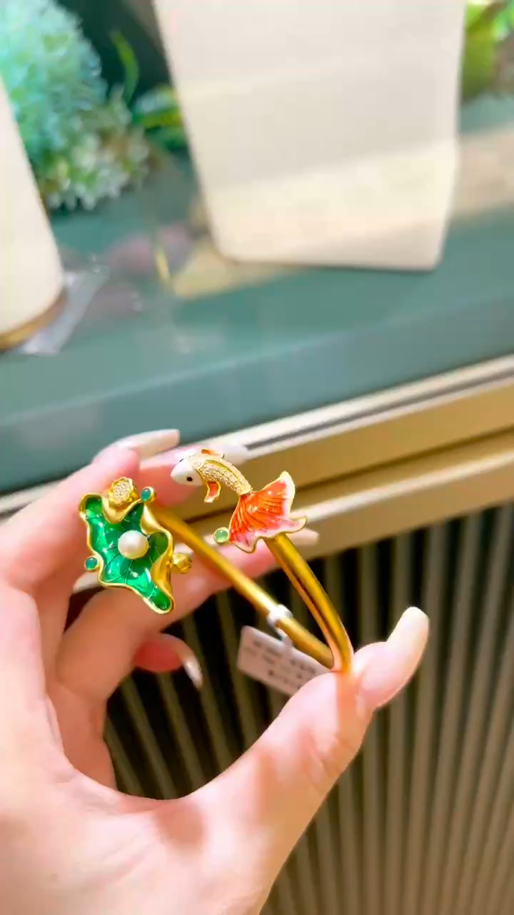 呜,这莲花和鱼结合在一起的黄金手镯,真靓眼