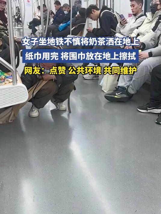 女子坐地铁不慎将奶茶洒在地上，纸巾用完 将围巾放在地上擦拭