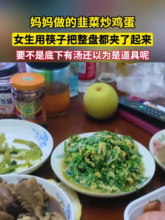 妈妈做的韭菜炒鸡蛋,女生用筷子把整盘都夹了起来