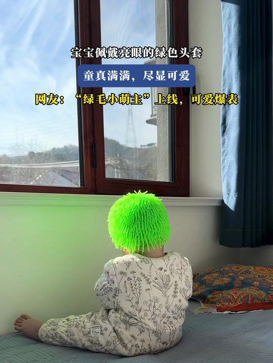 宝宝佩戴亮眼的绿色头套,童真满满,“绿毛小萌主” 可爱爆表