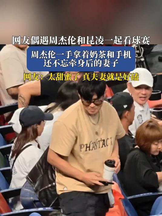 网友偶遇周杰伦和昆凌一起看球赛，周杰伦一手拿着奶茶和手机，还不忘牵身后的妻子，网友：太甜蜜