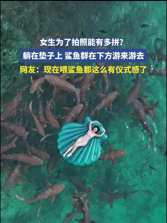 女生为了拍照能有多拼？躺在垫子上鲨鱼群在下方游来游去
