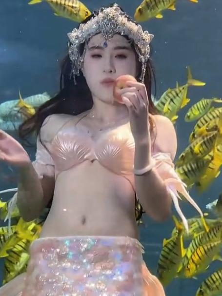 美人鱼身着连体鱼尾,在北海海底世界水下吃苹果,脆感十足
