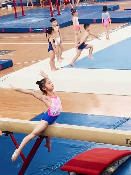 小女孩练体操，手臂上的肌肉线条特明显，背后的艰辛无法想象