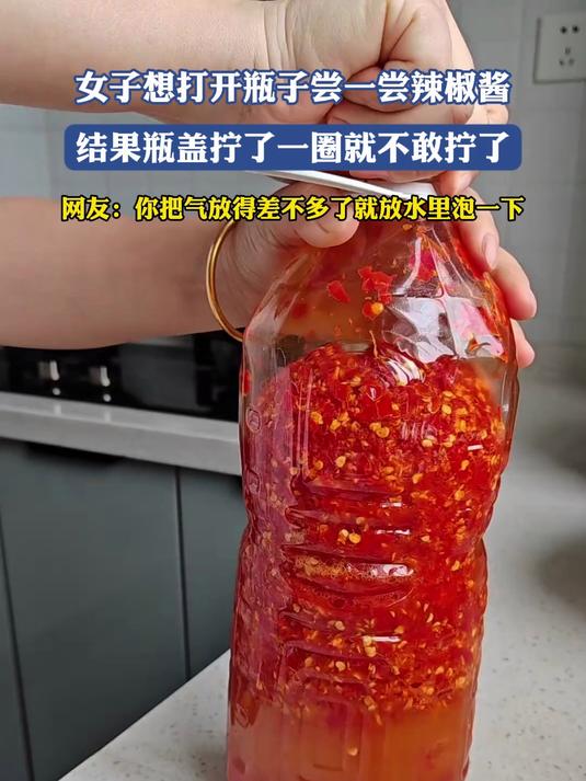 女子想打开瓶子尝一尝辣椒酱，结果瓶盖拧了一圈就不敢拧了