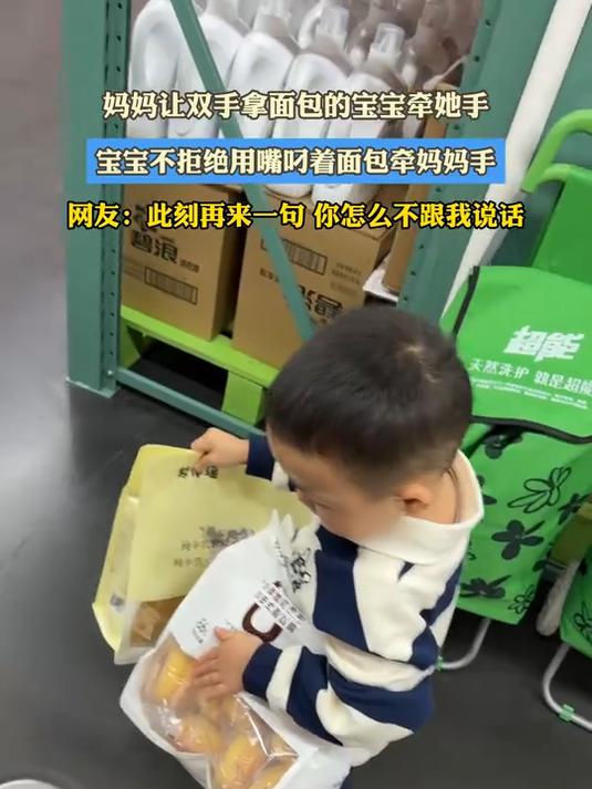 妈妈让双手拿面包的宝宝牵她手,宝宝不拒绝用嘴叼着面包牵妈妈手