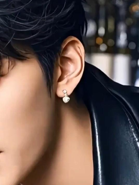 酒吧夜色迷人，黑衣男子轻啜鸡尾酒，眼神深邃引人入胜