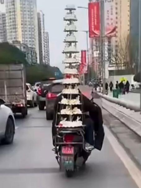 外卖小哥骑电动自行车“硬核”配送12层蛋糕。