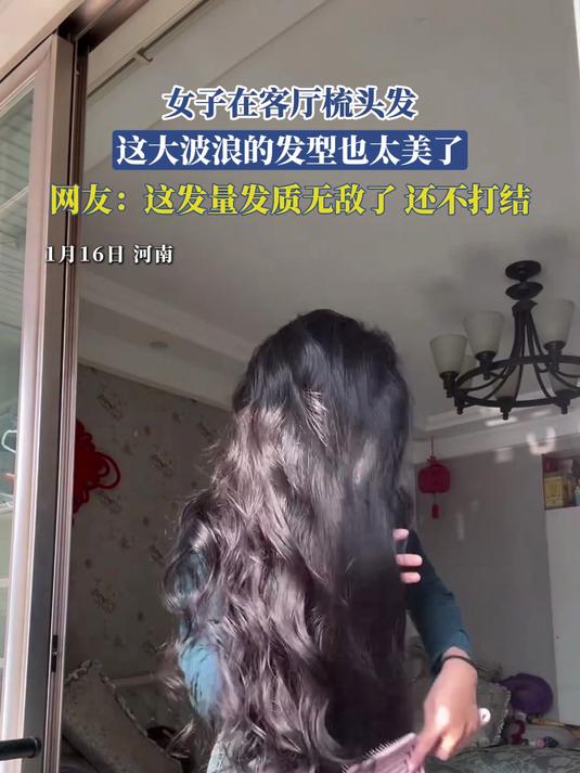 女子在客厅梳头发，这大波浪的发型也太美了
