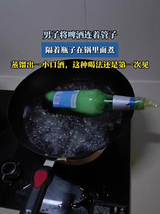 男子将啤酒连着管子,隔着瓶子在锅里面煮,蒸馏出一小口酒