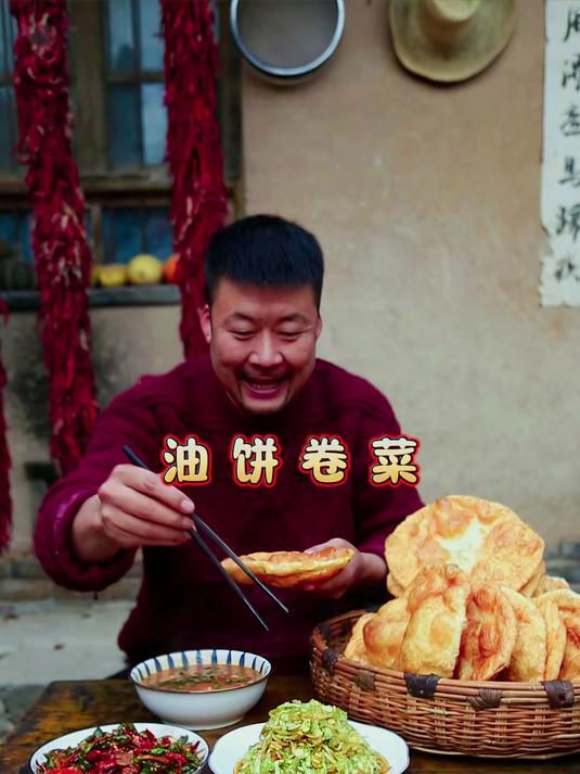 油饼卷菜，面团在热油中炸至金黄，外脆内软，出锅时滚烫松软