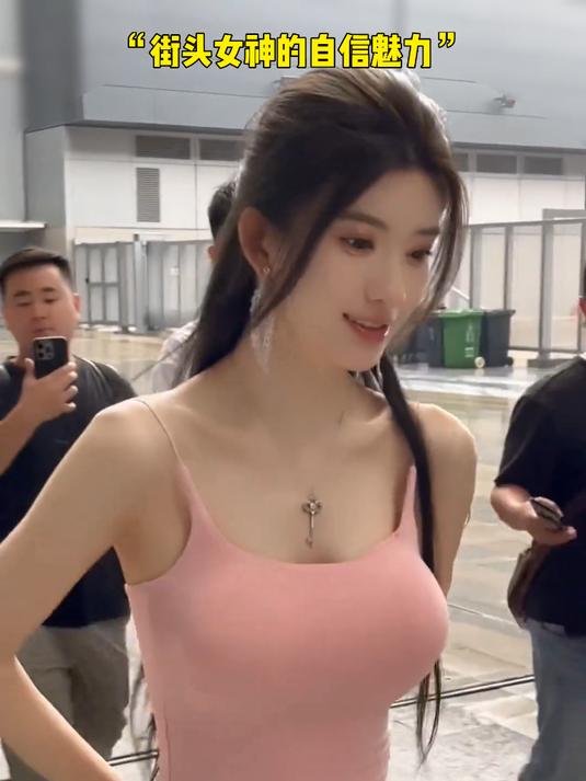 街头魅力:粉色吊带上衣与牛仔裤的完美搭配,吸引众人目光